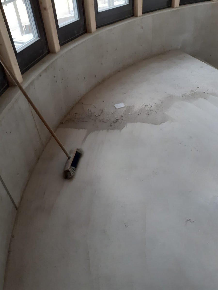 Betonboden mit Besen bei der Bodenreinigung